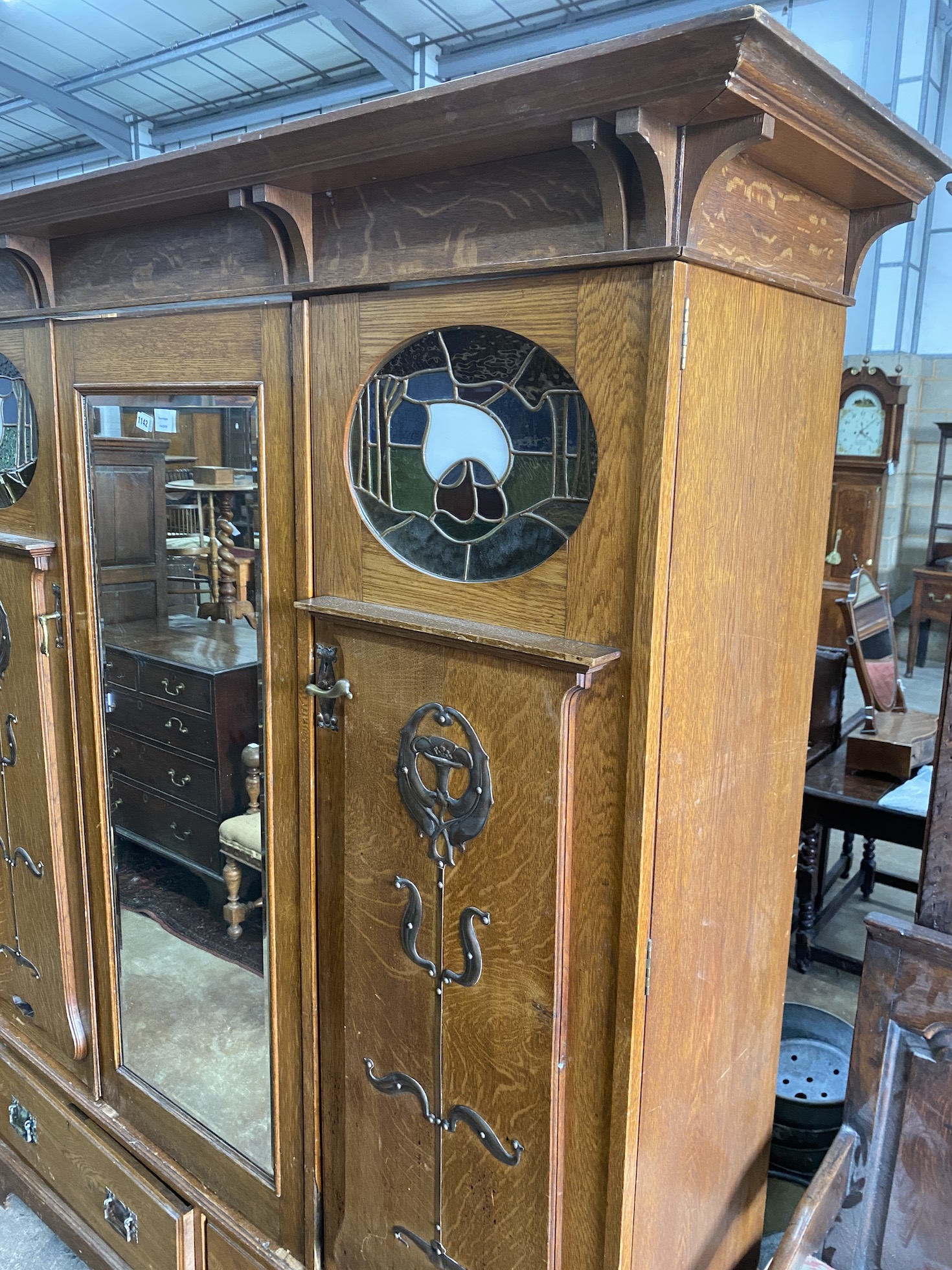 An Arts & Crafts copper and brass mounted oak compactum wardrobe in the style of Shapland & Petter, inset oval stained glass panels, width 185cm, depth 58cm, height 203cm